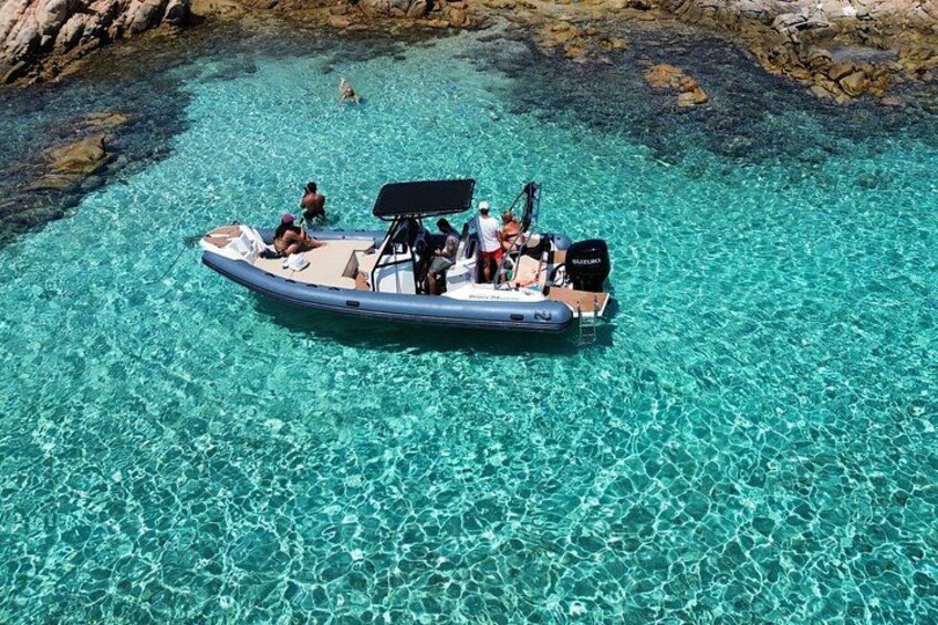 A boat with people on a clear turquoise sea. 1
