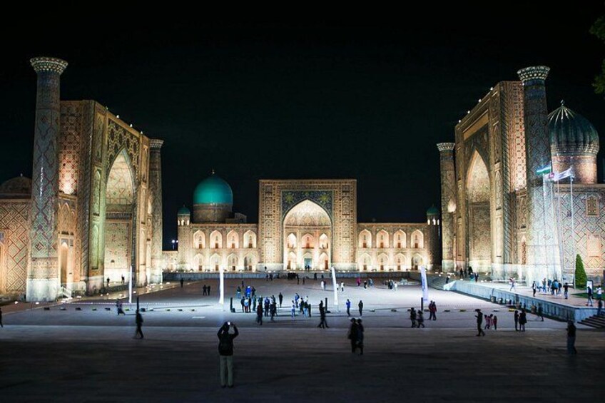 Una gran mezquita iluminada con cúpulas y arquitectura detallada, de noche. 2