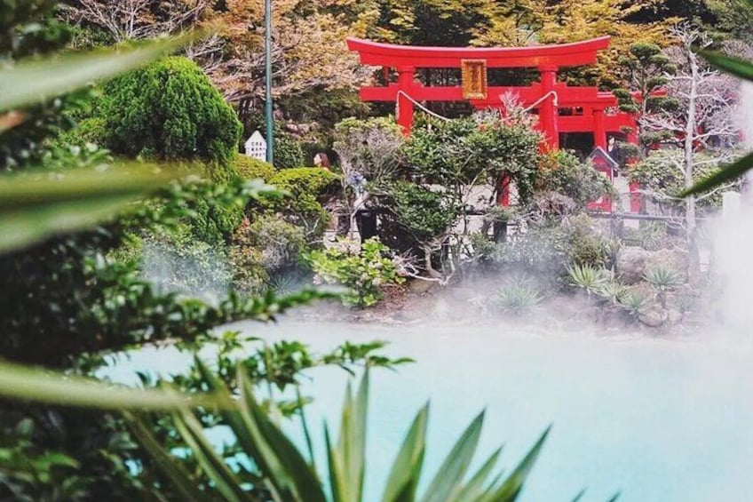 Un torii rojo, abundante follaje y una masa de agua. 4