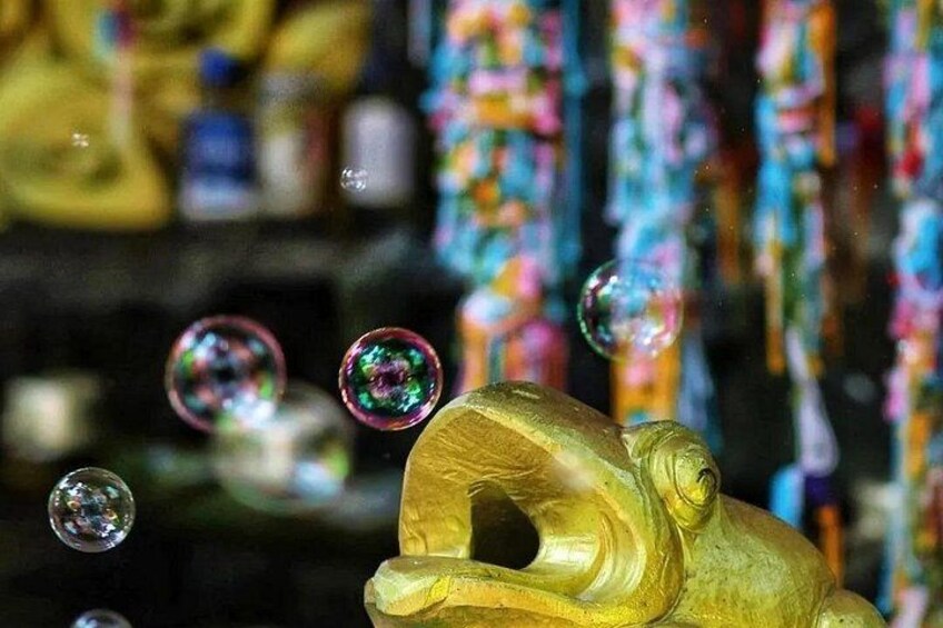 A golden statue with bubbles in the foreground. 5