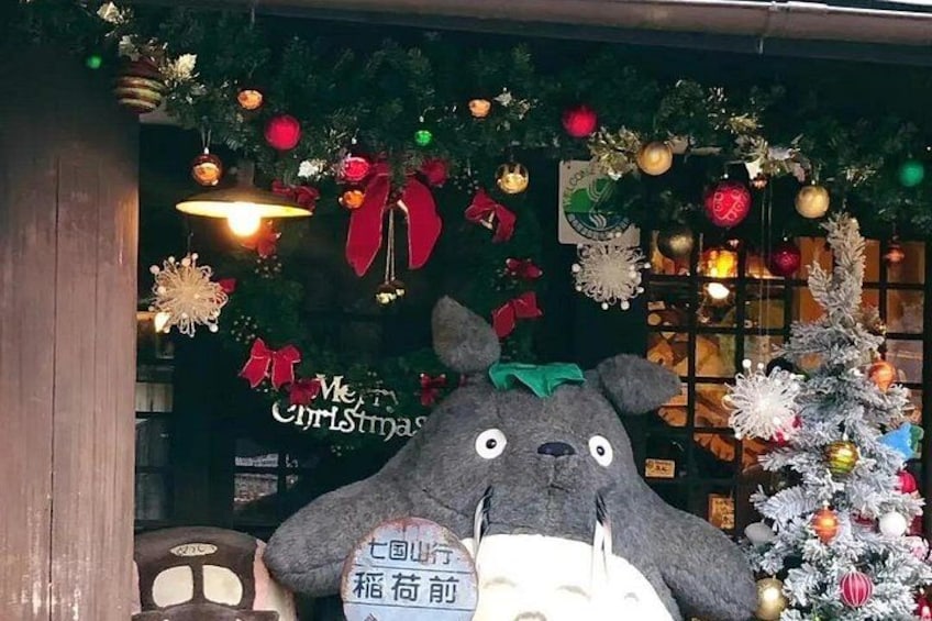 A Christmas display with a large stuffed animal, a decorated tree, and festive ornaments. 3