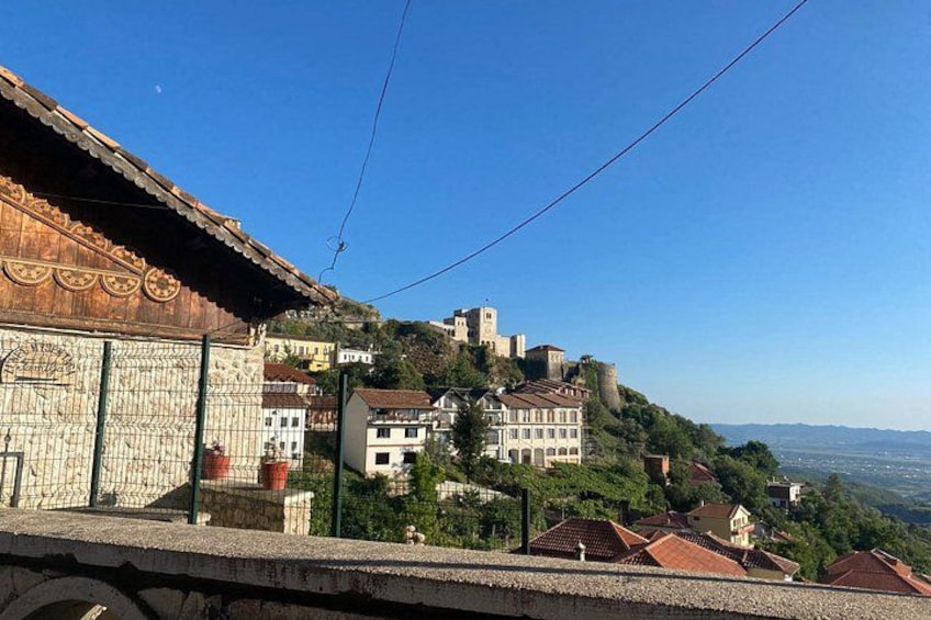 A historic town with a prominent castle on a hill, surrounded by lush greenery and traditional buildings. 5
