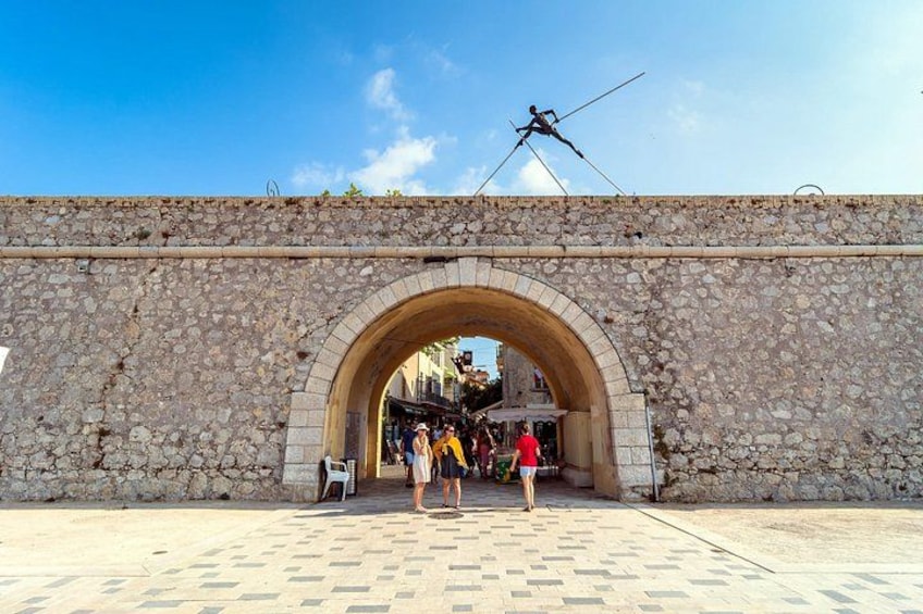 A stone archway with people walking through it. 4