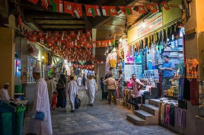 Una animada calle comercial con gente comprando y vendedores ofreciendo productos. 1