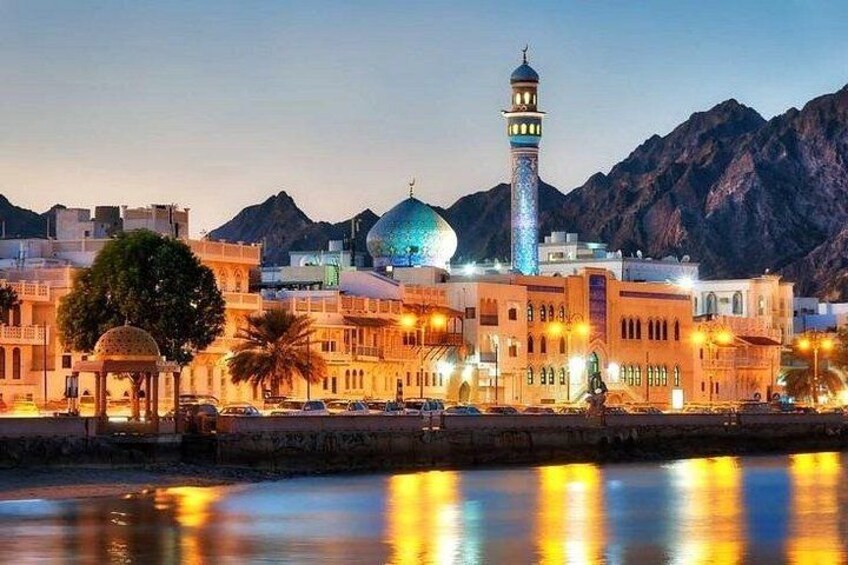 Una mezquita con un minarete, una cúpula y un río que refleja luces. 5