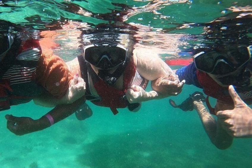 Tre personer som snorklar under vattnet. 2