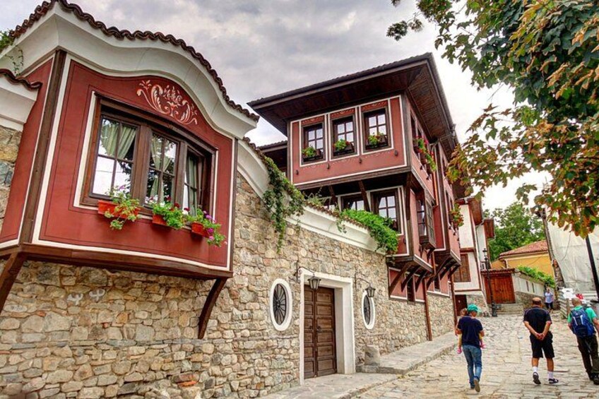 A traditional building with stone walls, wooden balconies, and flower boxes. 2