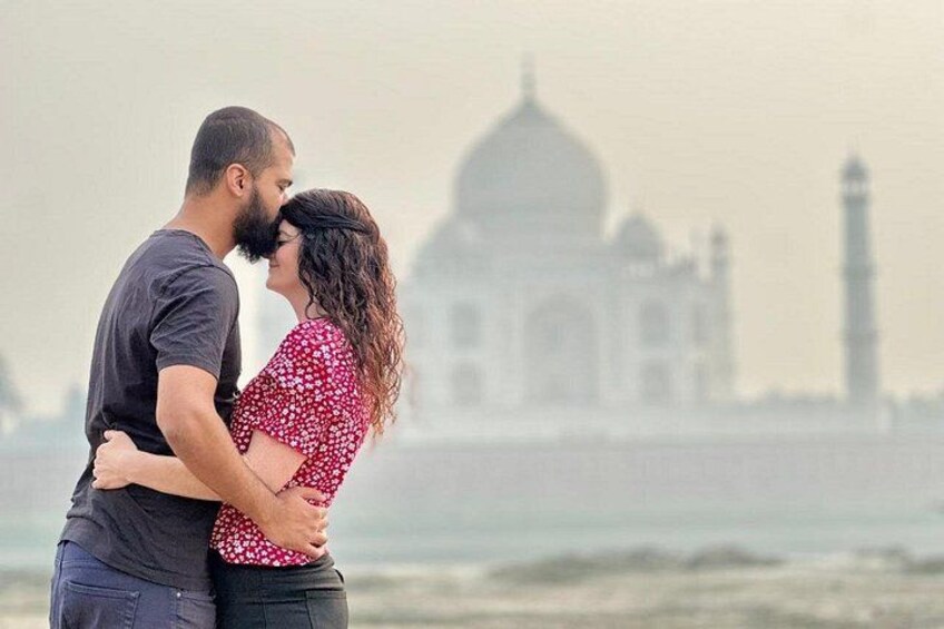 A couple embracing with the Taj Mahal in the background. 2