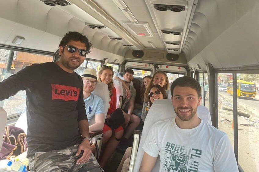 A group of people on a bus with seats and windows. 5