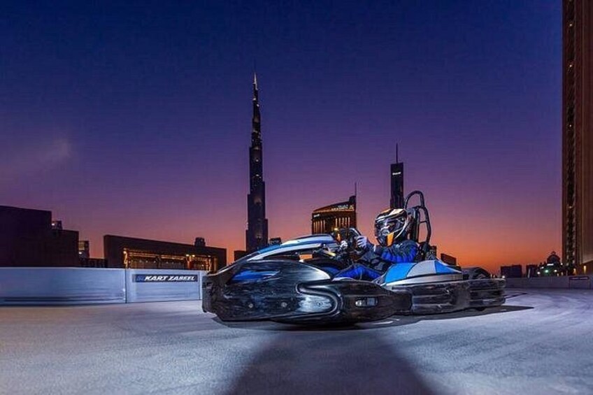 A go-kart on a track with a city skyline in the background. 3