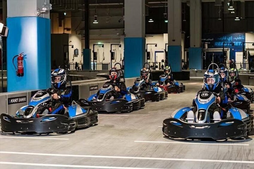 A go-kart track with multiple go-karts and riders. 5