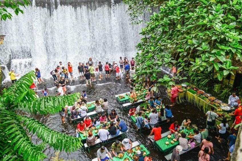 A waterfall with people dining at tables below. 3