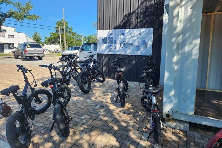 A row of bicycles parked outside a building with a sign that reads 'CARGO Logistics.' 4
