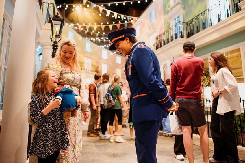 A person in a uniform interacting with a child in a shopping area. 3