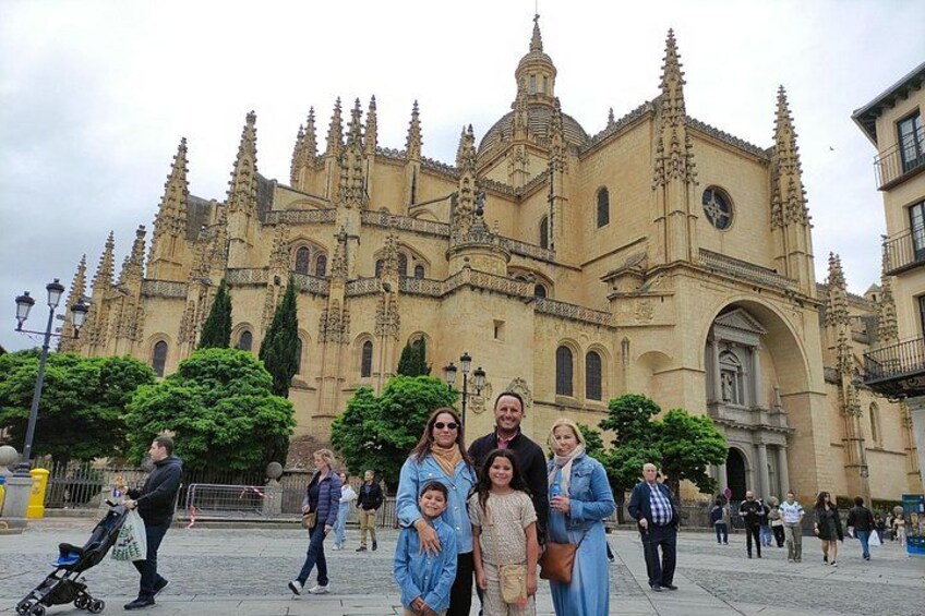 Un grupo de personas frente a una gran catedral ornamentada con múltiples torres y un campanario. 2