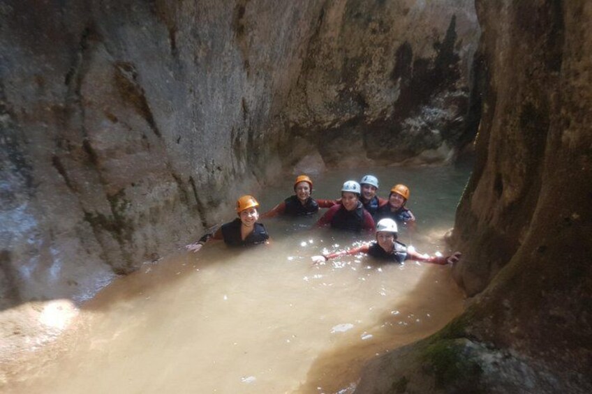Un grupo de personas en un cañón estrecho con agua, usando cascos y chalecos salvavidas. 5