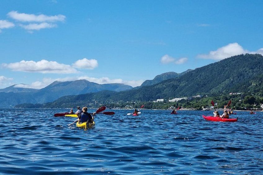 People kayaking on a lake with mountains in the background. 4