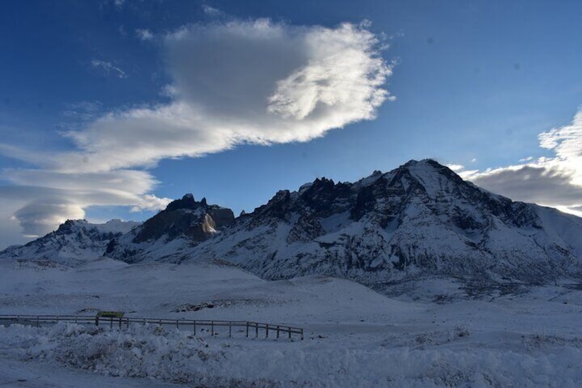 A snow-covered mountain range with a fence in the foreground. 5