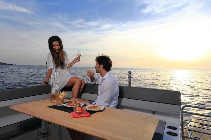 A couple dining on a boat with a sunset in the background. 3