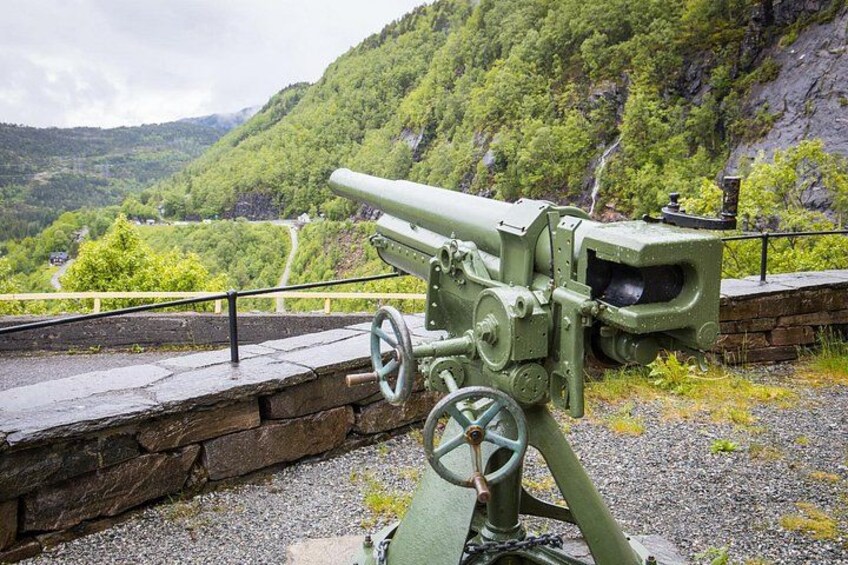 En militær kanon på en stenplatform med et smukt bjerglandskab i baggrunden. 1