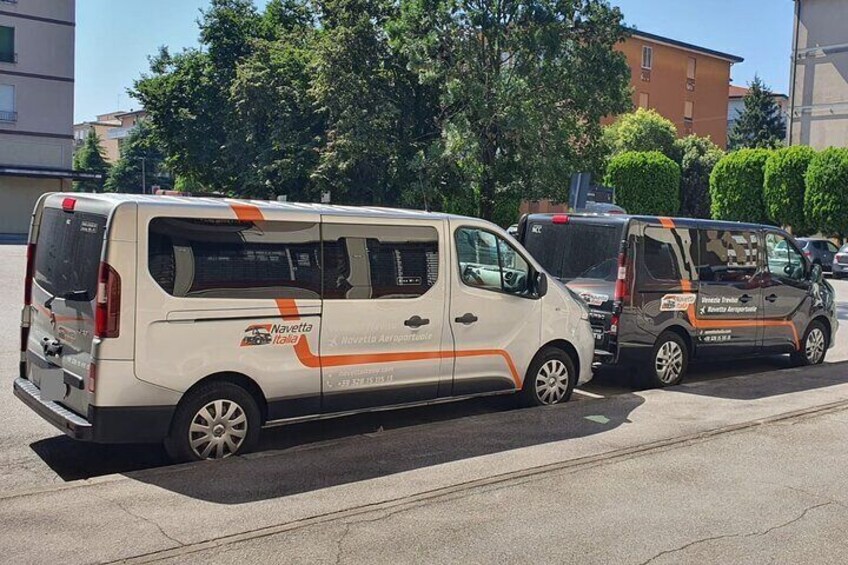 Una camioneta blanca con franjas anaranjadas estacionada en una calle. 4
