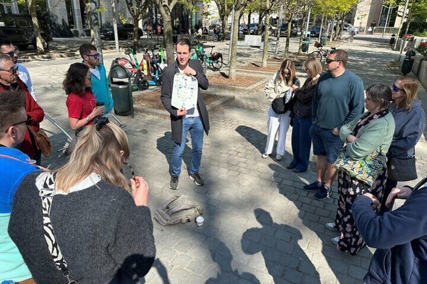 A group of people gathered around a man in a park. 5
