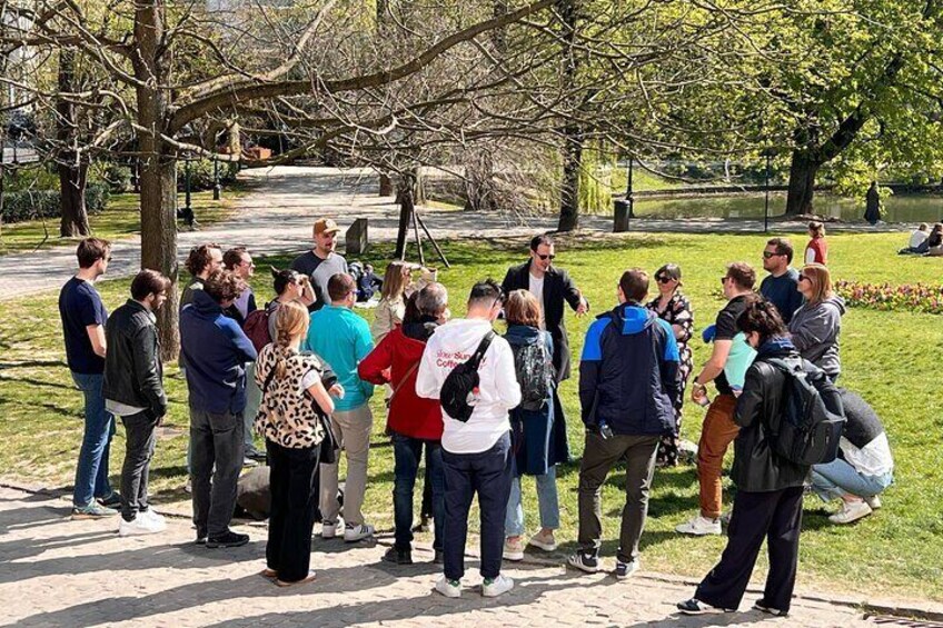 A group of people gathered outdoors in a park, standing and conversing. 4