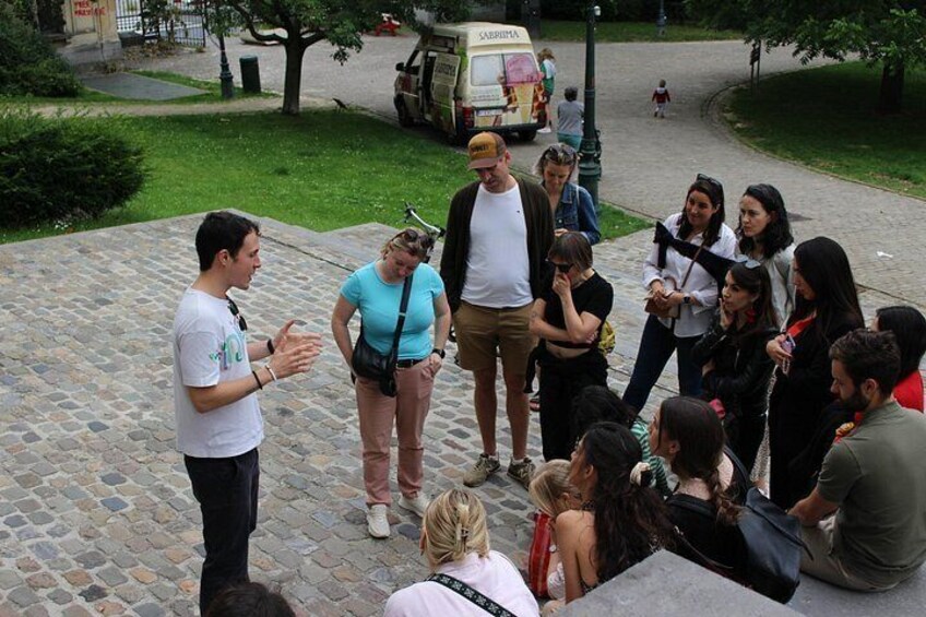 A group of people gathered on a cobblestone path in an outdoor setting. 2