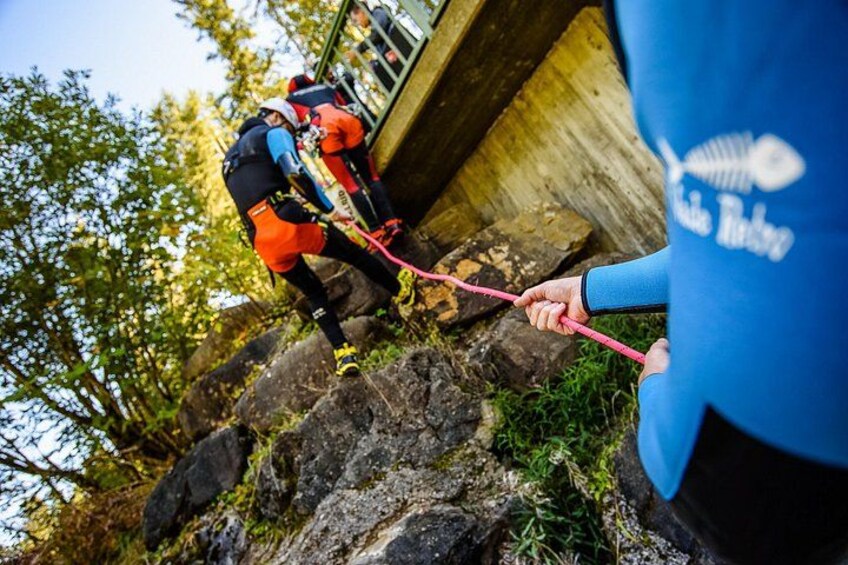 A person rappelling down a rocky cliff with a rope. 3
