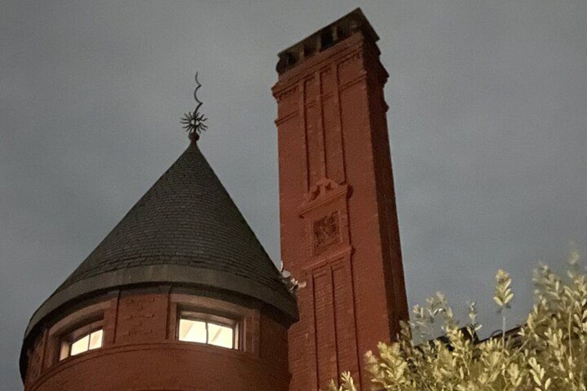 A brick tower with a conical roof and a weather vane. 2