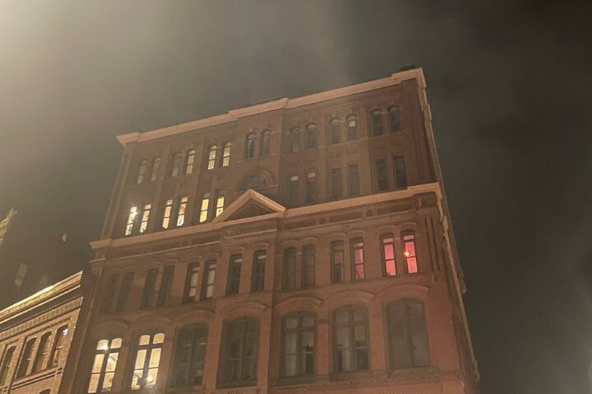 A multi-story building with illuminated windows and a classical architectural style. 2