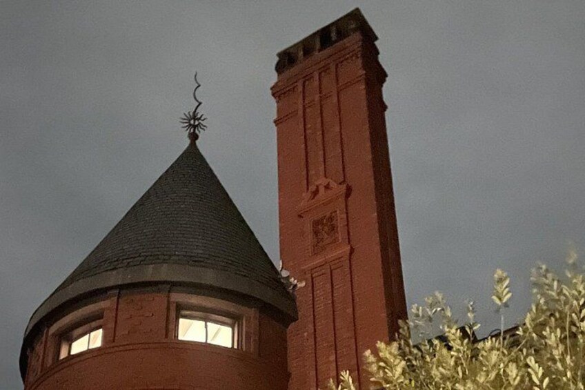 A brick tower with a conical roof and a weather vane. 5