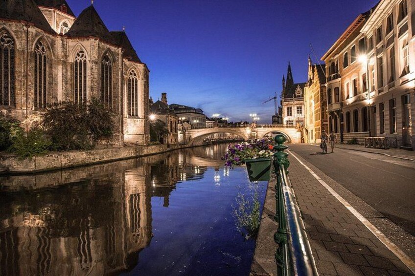 Un canal bordé de bâtiments des deux côtés, un pont en arrière-plan et un reflet dans l’eau. 3