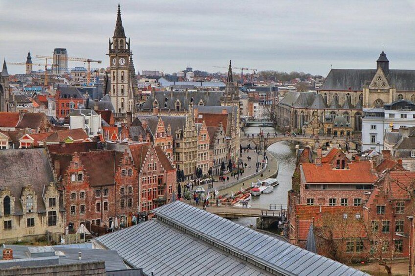 Un paysage urbain avec des bâtiments historiques, un imposant beffroi et une rivière. 4