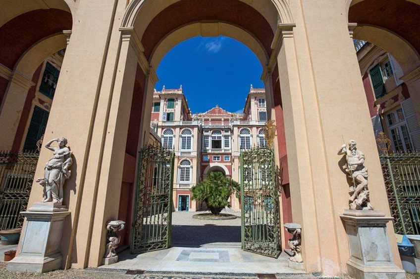 A grand entrance with arches, statues, and a large building in the background. 3