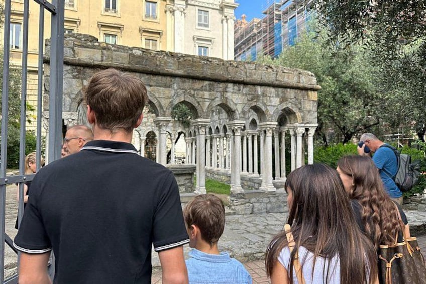 Tourists observing a historical stone structure with columns. 1