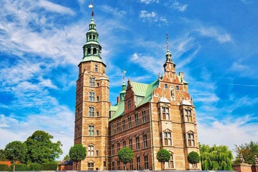 A historic building with two prominent towers and a green roof. 4