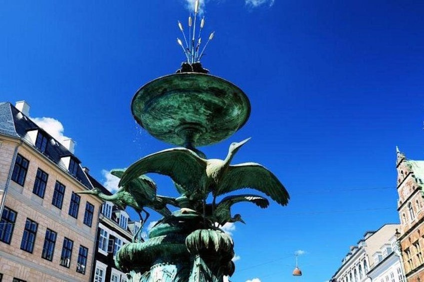 A multi-tiered fountain with water jets, surrounded by historic buildings. 5