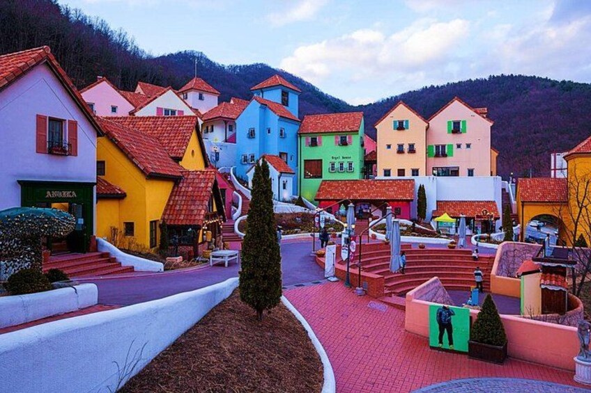 Colorful houses, a winding path, and a mountainous backdrop. 2