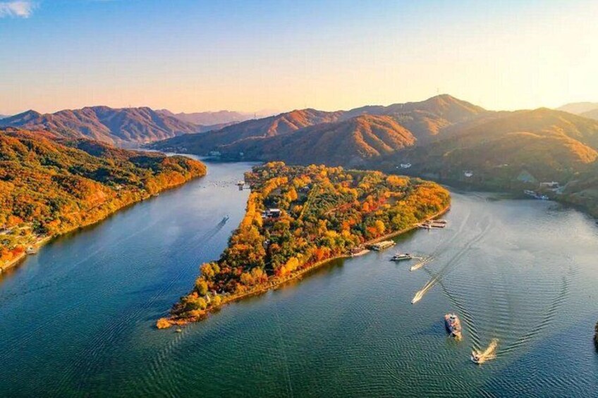 A river winding through a mountainous landscape with autumn foliage. 1