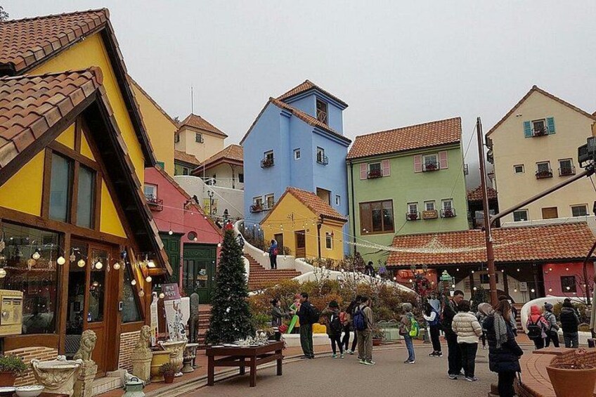 A colorful street with shops and a Christmas tree. 3