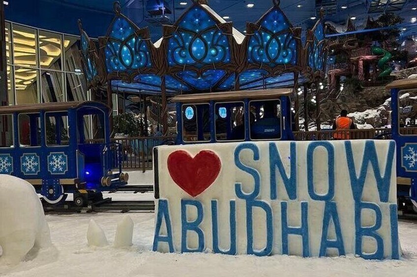 A snow-themed attraction with a sign reading "I ♥ SNOW ABUDHABI" and snow sculptures. 4