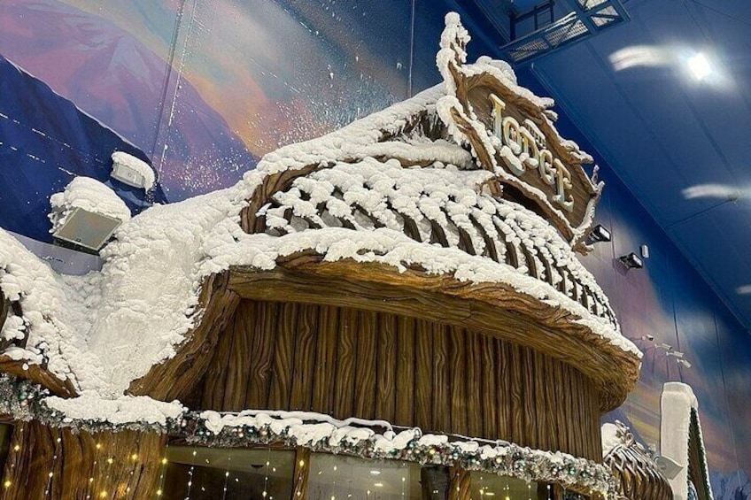 A snow-covered wooden structure with a sign that reads "JOGT". 2