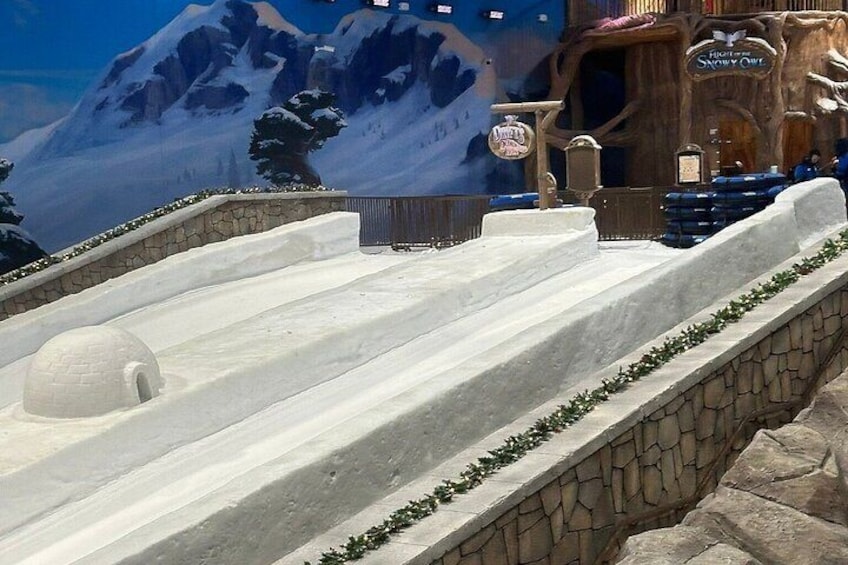 A snow-covered slide with a wooden structure in the background. 3