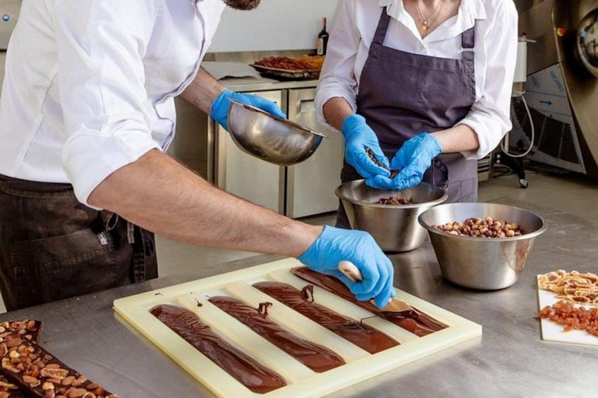 To personer med handsker forbereder chokoladebarer i et køkken. 4