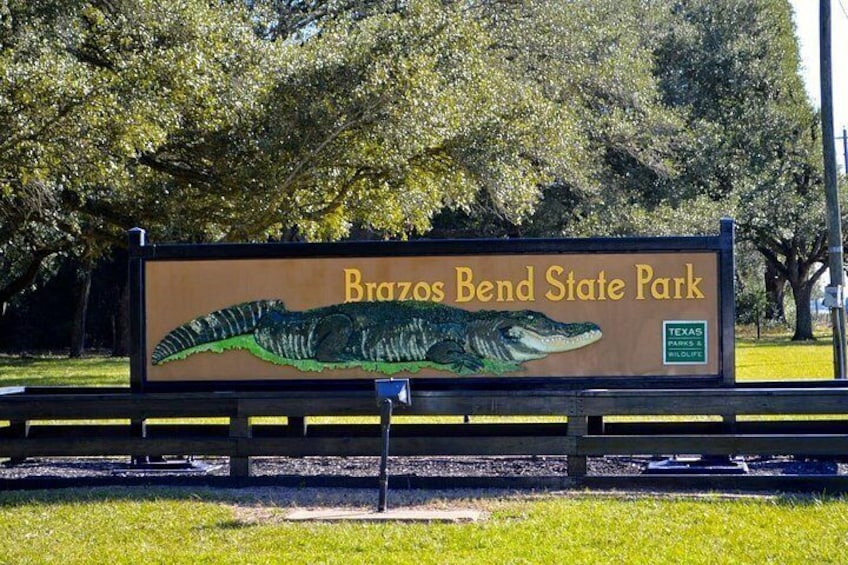 A billboard for Brazos Bend State Park with a depiction of a crocodile. 3