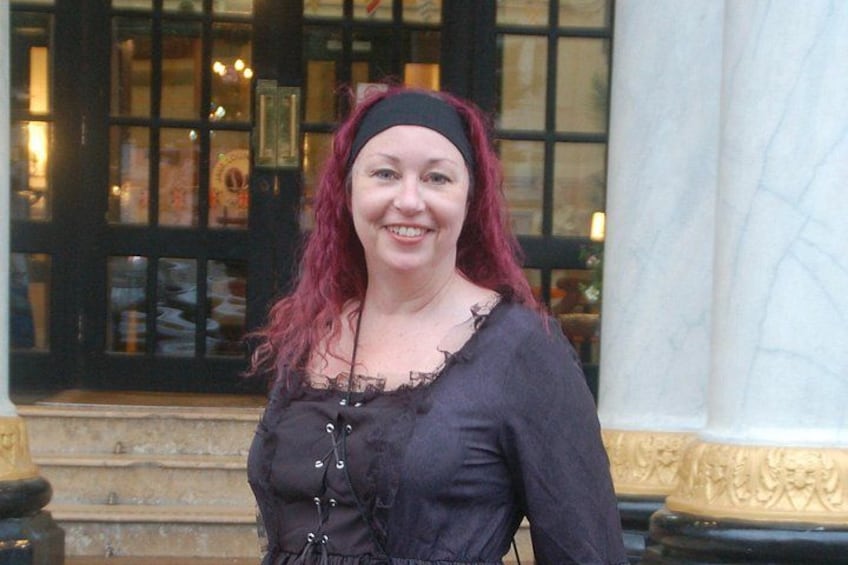 A person standing in front of a building with a large window and a column. 3
