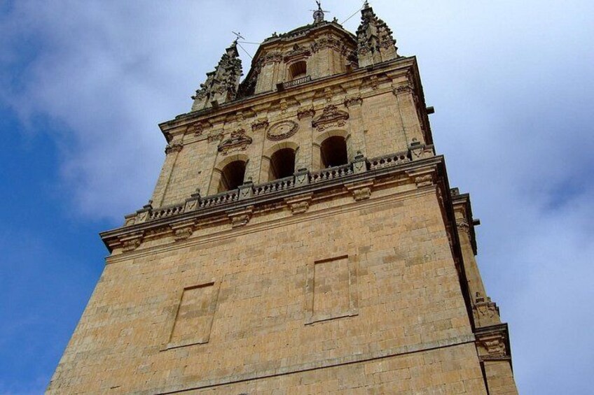 A tall, historic stone tower with intricate architectural details, including a clock and decorative elements at the top. 4