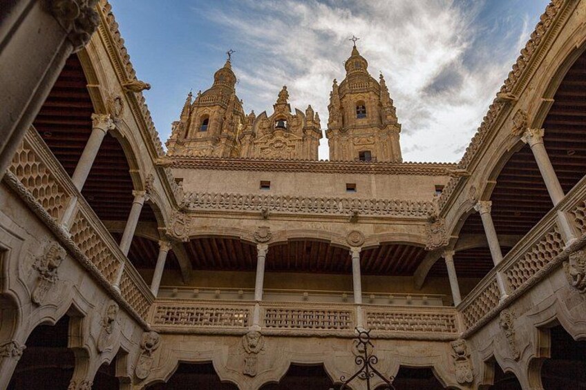 A historic building with ornate architecture, including a balcony and two towers. 3