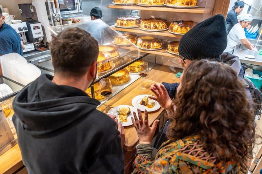 A bakery with people ordering and serving food. 2